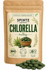 SPINTZ Bio-Chlorella-Presslinge im Kraftpapierbeutel mit grünen Algentabletten im Vordergrund.
