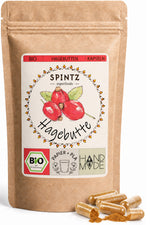 SPINTZ Bio-Hagebutten-Kapseln im Kraftpapierbeutel mit goldbraunen Kapseln im Vordergrund.