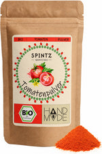 SPINTZ Bio-Tomatenpulver im Kraftpapierbeutel mit rotem Tomatenpulver im Vordergrund.