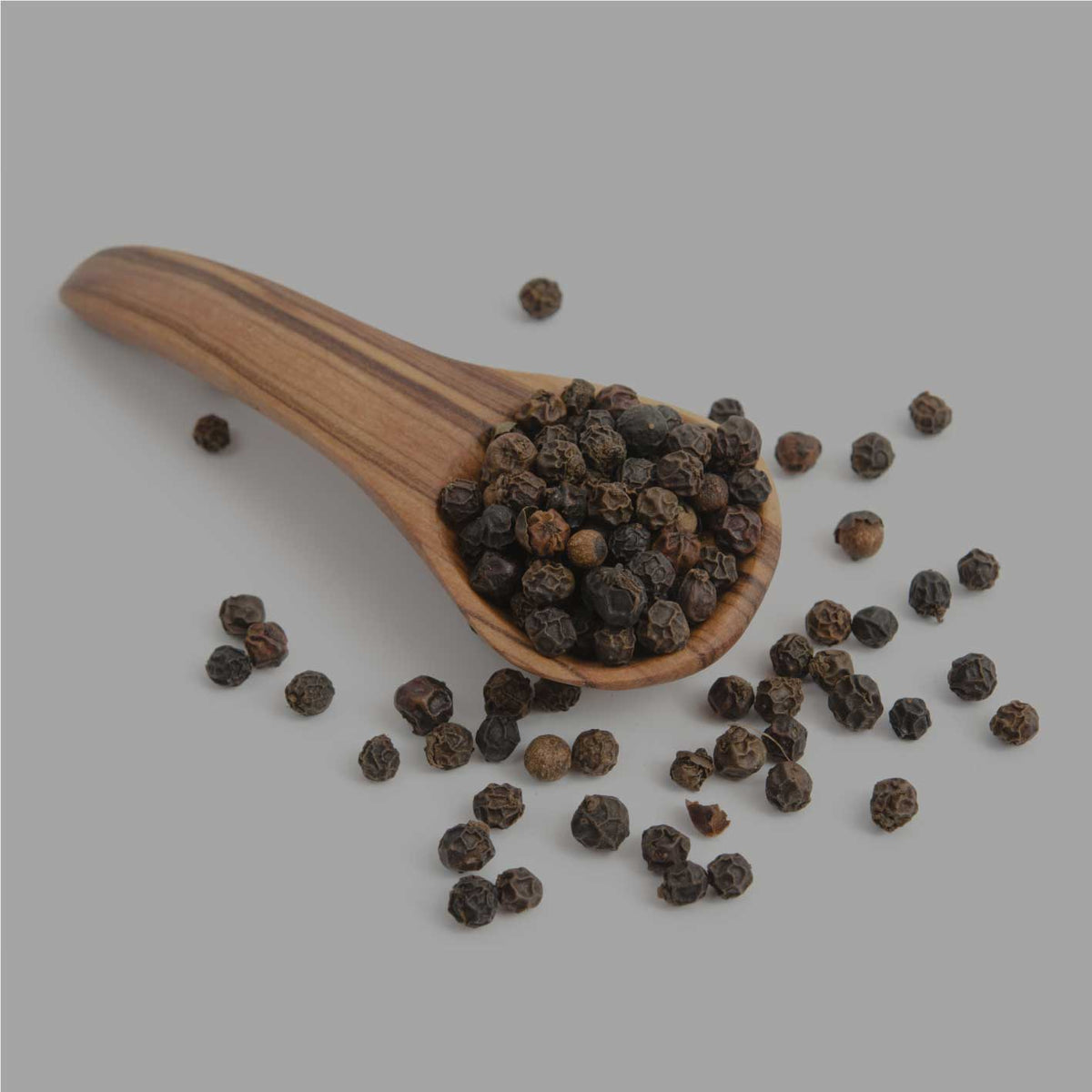 Ganze schwarze Pfefferkörner in Holzlöffel – aromatisch, handverlesen und naturbelassen